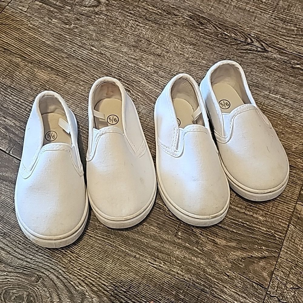 Two pair of toddler slide on white shoes